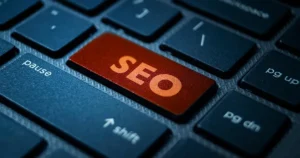 Close-up of a laptop keyboard with a highlighted orange key displaying the text SEO for professional search engine optimization services.